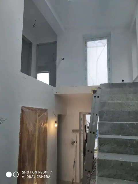 Vymalovaný interiér novostavby se schodištěm